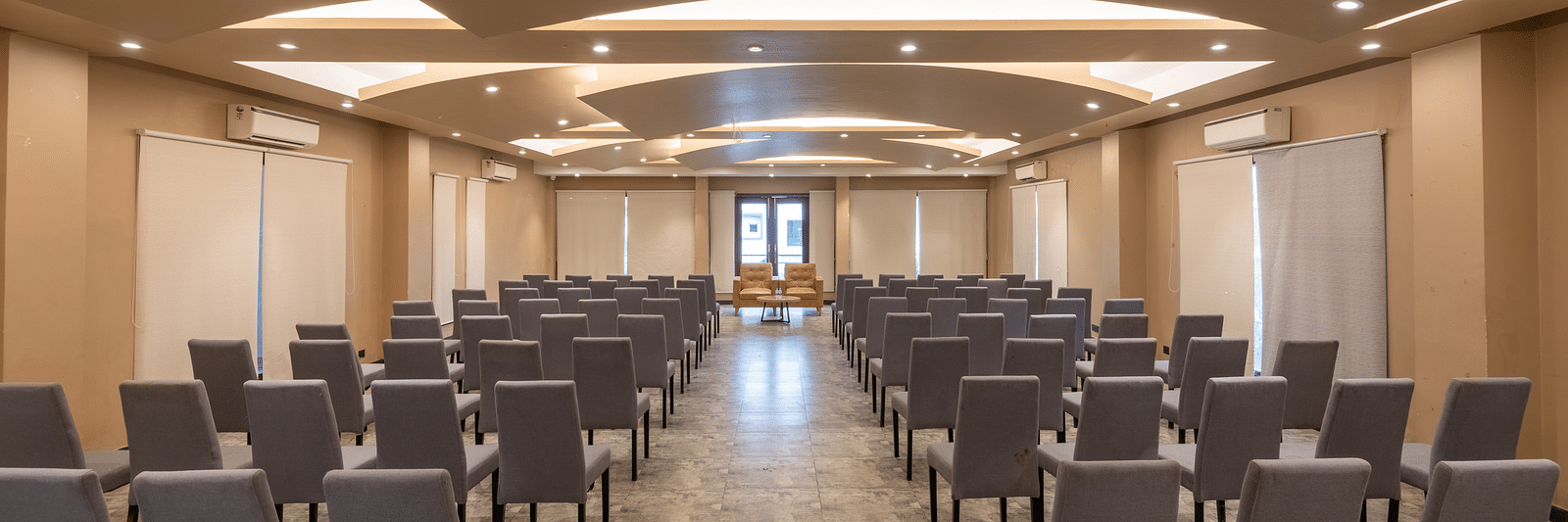 View from the back of the banquet hall at DLS Forest Vines Resort, with chairs neatly arranged on both sides.